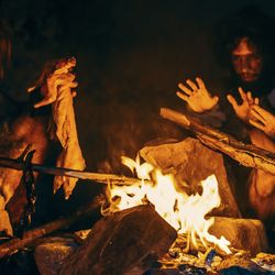 Ancient humans sitting around a fire