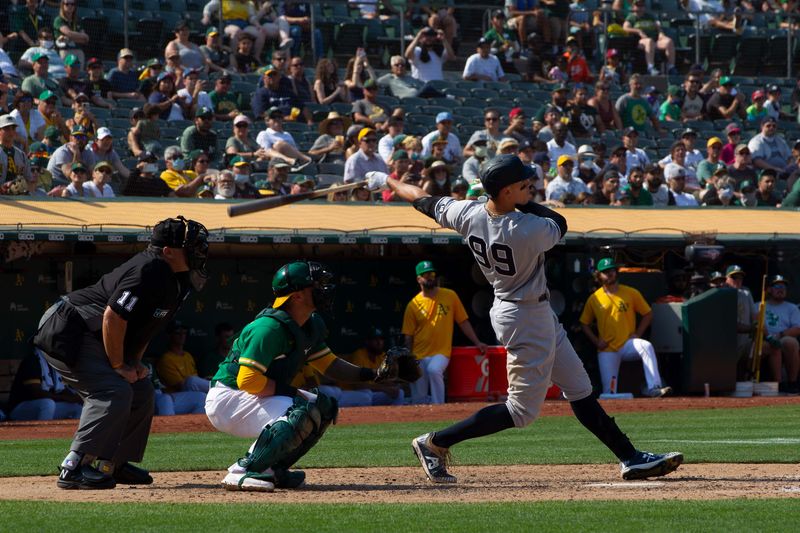 aron Judge #99 of the New York Yankees hits a 9th inning home run against the Oakland Athletics at Ring Central Coliseum