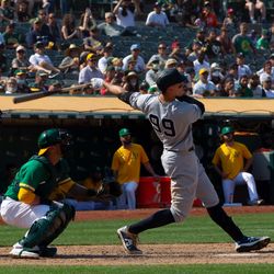 aron Judge #99 of the New York Yankees hits a 9th inning home run against the Oakland Athletics at Ring Central Coliseum