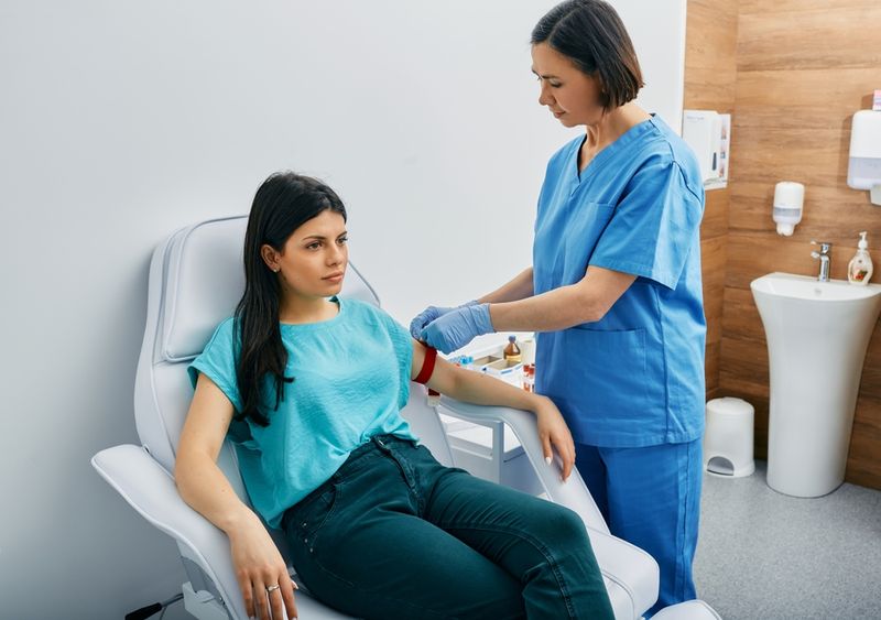 A woman at a doctor's surgery receiving a blood test from a nurse.