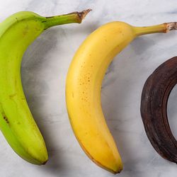 Process of ripening for banana showing a fresh green to yellow banana on left, an optimal ripened yellow banana in middle and a stale banana that turned dark brown due to enzymatic browning on right