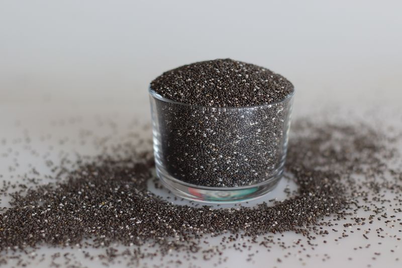 Heap of highly nutritious chia seeds inside a glass bowl. Chia seeds or Salvia hispanica, also called Salba chia or Mexican chia, are the edible seeds of a flowering plant from the mint family.