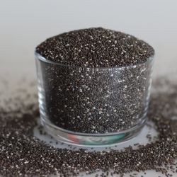 Heap of highly nutritious chia seeds inside a glass bowl. Chia seeds or Salvia hispanica, also called Salba chia or Mexican chia, are the edible seeds of a flowering plant from the mint family.