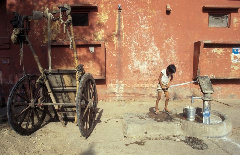 Child at water station in Province of Uttar Pradesh in India. India, Agra, April, 1998