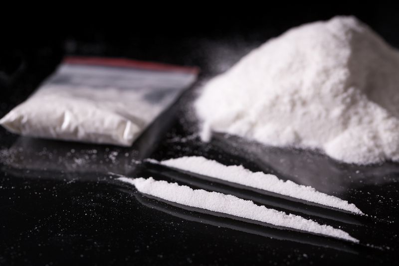 Two lines of cocaine and a bag of white powder illicit drugs. 
