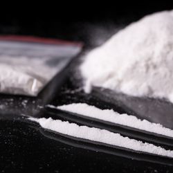 Two lines of cocaine and a bag of white powder illicit drugs. 