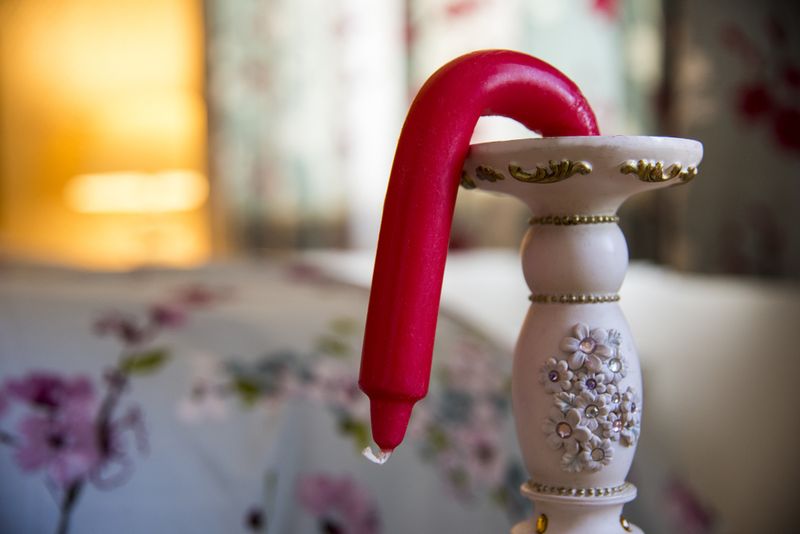 A pink candle that's flopping down melted, symbolizing erectile disfunction of penis.