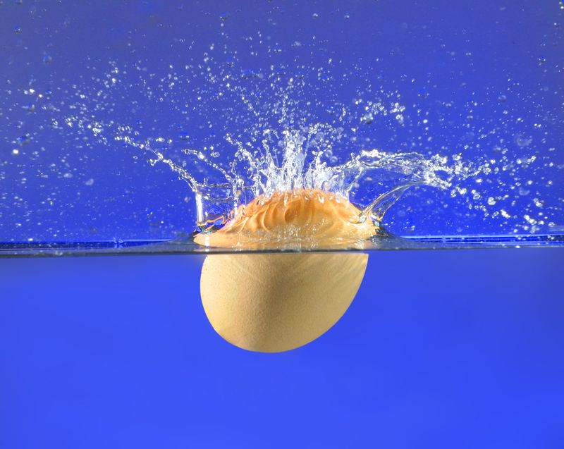 An egg splashing into water 