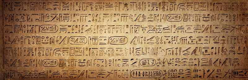 Ancient Egyptian hieroglyphs carved into a wall background.