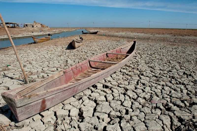 A traditional Marsh Arab canoe known as a Mashoof abandoned on the dry earth of the southern marshes of Iraq during a harsh summer drought caused by climate change and political instability