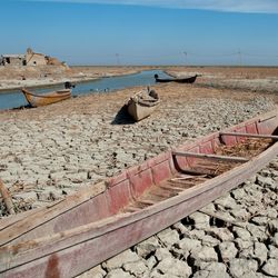 A traditional Marsh Arab canoe known as a Mashoof abandoned on the dry earth of the southern marshes of Iraq during a harsh summer drought caused by climate change and political instability