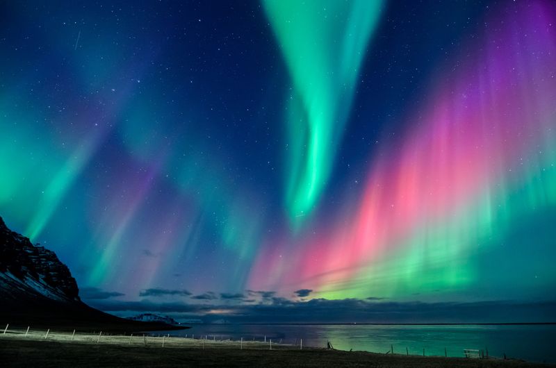 Glorious auroras in green, pink and purple swoosh across the night sky