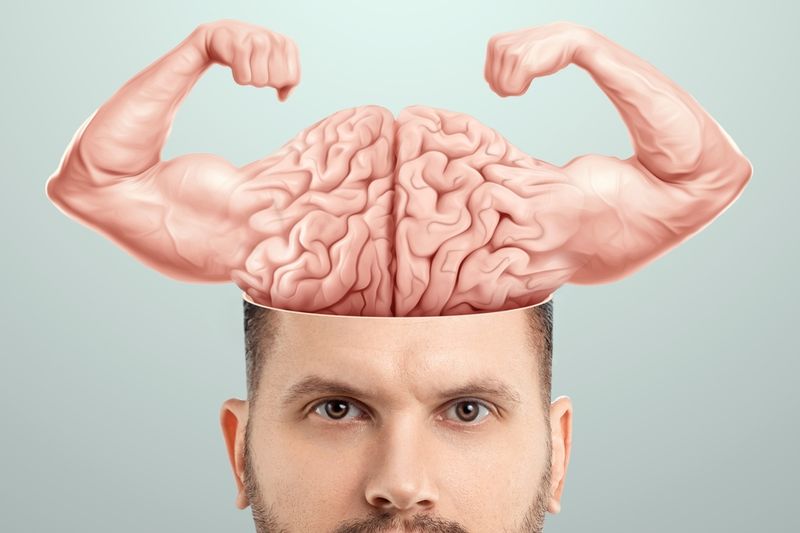 Illustration of a brain with human, muscled, flexing arms emerging out of the top of a man's head