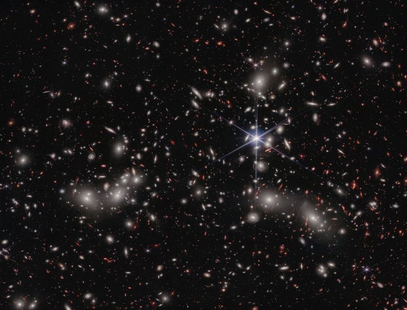 The bright white sources with a hazy glow in this JWST deep field image are the galaxies of Pandora's Cluster coming together to form a mega cluster