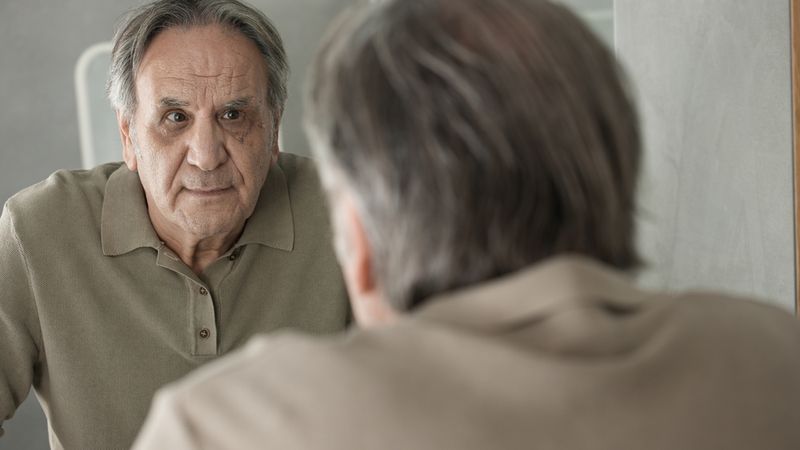 Old man looking in mirror