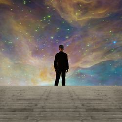 Person in black suit at the top of stairs facing a rainbow nebula