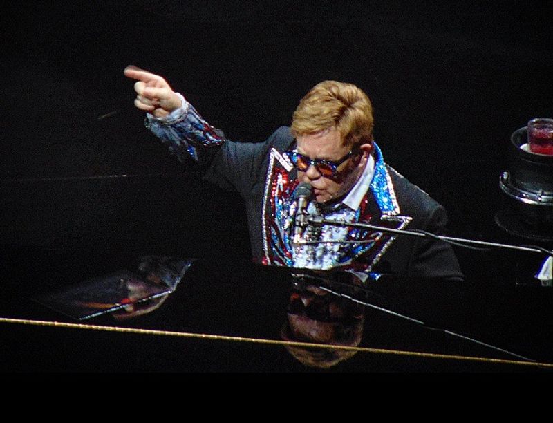 Sir Elton John singing and playing piano