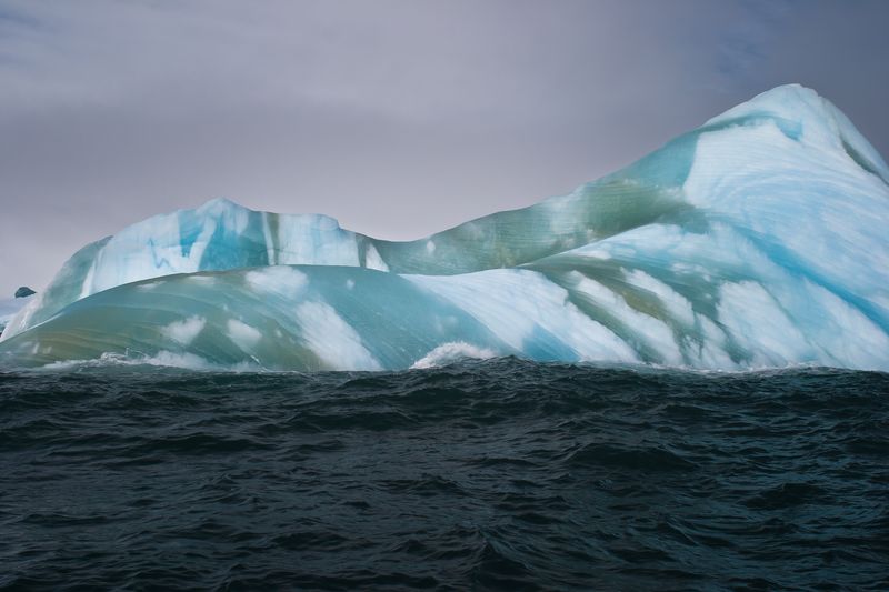 Big floating iceberg with blue and green sections
