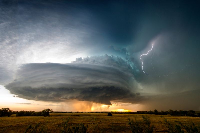 A stunning "wedding cake" supercell seen during a sunset near Severy, Kansas, with lightning strike the side.