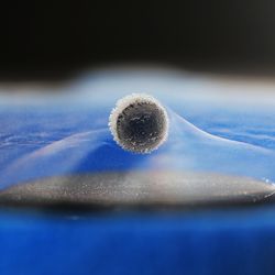 a superconducitng sphere is levitated above a magnet. the material is not a room temperature and the evaporation of liquid nitrogen is visible around it.