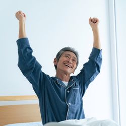 seniors waking up refreshed in bed. Hospital bed. blue pajamas