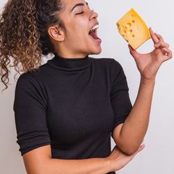 Woman eating a chunk of cheese