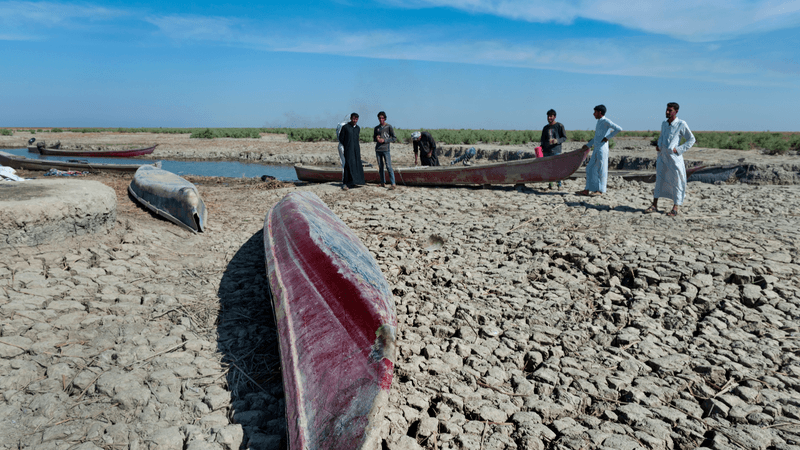 Boats on dried cracked earth during a drought in the Southern Marshes of Iraq