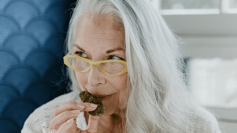 A senior woman sniffs cannabis.