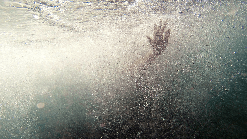 A hand, outstretched underwater.