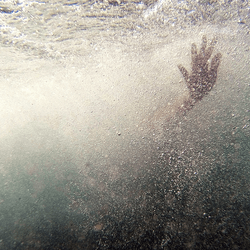 A hand, outstretched underwater.