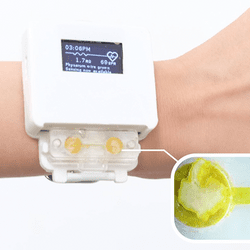 Wrist with a white smart watch, at the bottom of the watch is a slime mold compartment.